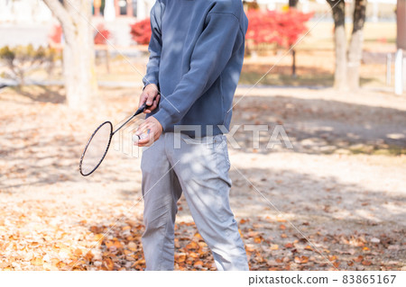 A man with a badminton racket A refreshing man exercising A man with a badminton racket A refreshing man exercising 83865167