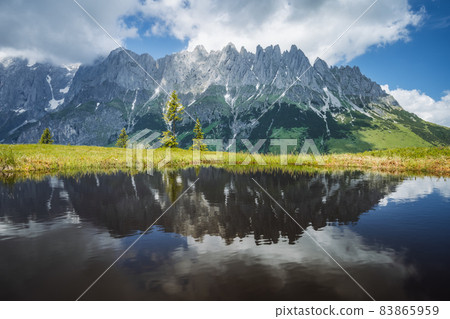 Mountain pond with Wilder Kaiser range reflecting in water pond, Tirol - Austria Mountain pond with Wilder Kaiser range reflecting in water pond, Tirol - Austria 83865959