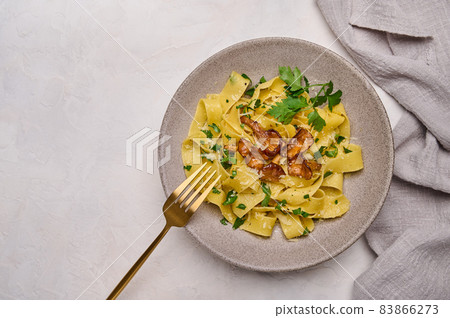 Flat lay pasta pappardelle with mushrooms chanterelles, cheese and parsley on plate Flat lay pasta pappardelle with mushrooms chanterelles, cheese and parsley on plate 83866273