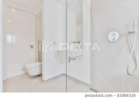 Minimalist bright bathroom with toilet, faucet and shower tall 83866326