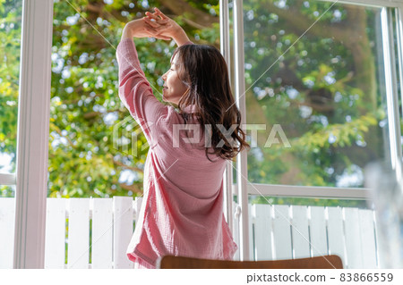 一個清爽的女人站在窗邊沐浴晨光 一個清爽的女人站在窗邊沐浴晨光 83866559