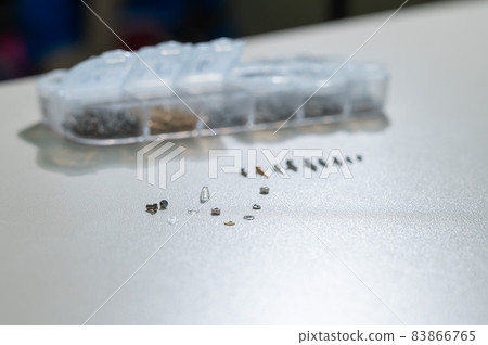 Bolts for repairing eyeglass frames on a white background. 83866765