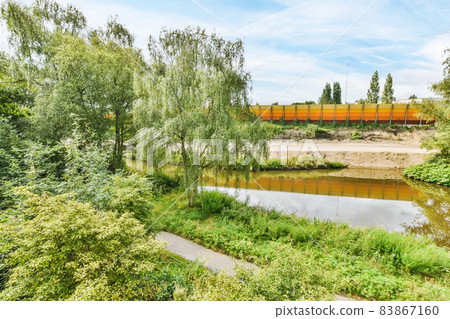 Environment with greenery, a large pond and fence Environment with greenery, a large pond and fence 83867160