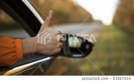 man giving thumbs up out his car while road trip. High quality beautiful photo concept man giving thumbs up out his car while road trip. High quality beautiful photo concept 83867810