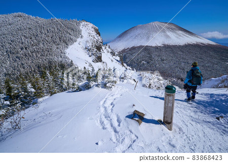 View Mt. Asama on the prefectural border between Nagano and Gunma prefectures in winter with the signpost of Yarigasaya 83868423