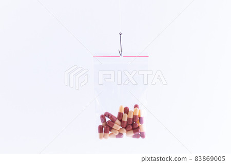 Colored Pills or Tablets Hanging in Small Ziplock Bag on a Fishing Hook 83869005