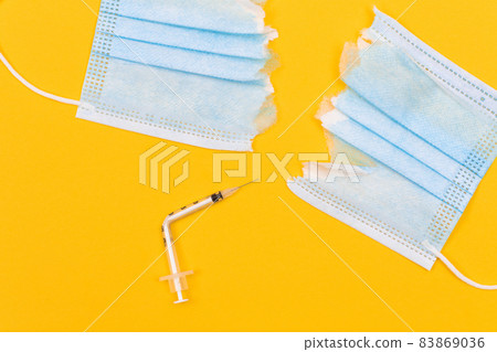 Broken Medical Syringe and Torn Medical Face Mask 83869036