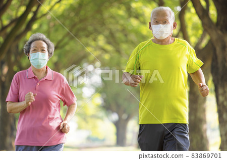 Senior couple in face mask and jogging in the park 83869701