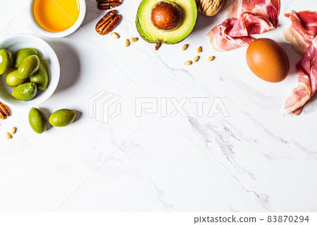 Keto diet ingredients frame on white marble background, copy space. Low carbohydrate menu concept. Keto diet ingredients frame on white marble background, copy space. Low carbohydrate menu concept. 83870294