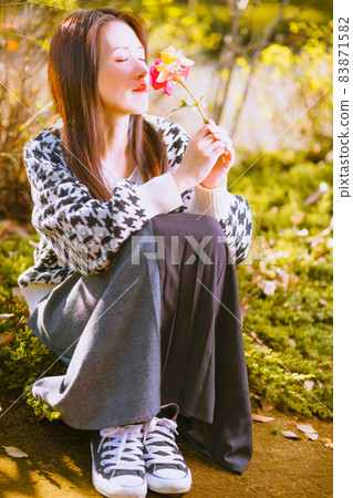 一個喜歡從切花中散發出秋玫瑰香味的可愛女孩 一個喜歡從切花中散發出秋玫瑰香味的可愛女孩 83871582