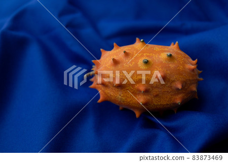 Kiwano image photo of spooky fruit red background Kiwano image photo of spooky fruit red background 83873469