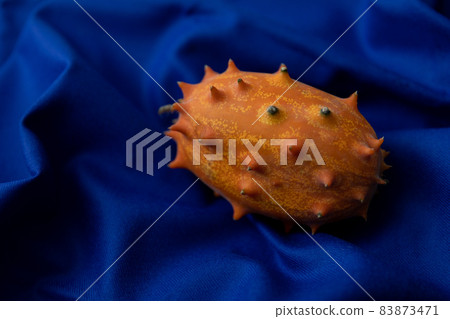 Kiwano image photo of spooky fruit red background 83873471