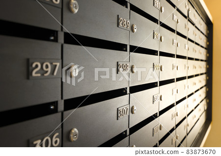 Mailboxes for letters and correspondence. Modern black mailboxes with numbers in the lobby of a residential or office building Mailboxes for letters and correspondence. Modern black mailboxes with numbers in the lobby of a residential or office building 83873670