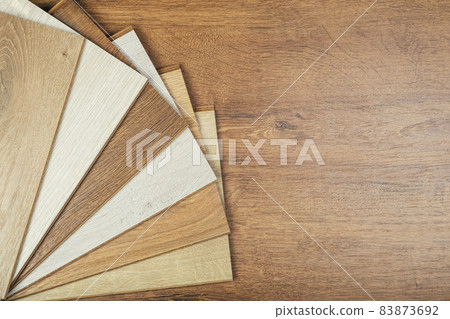 Laminate background. Samples of laminate or parquet with a pattern and wood texture for flooring and interior design. Production of wooden floors Laminate background. Samples of laminate or parquet with a pattern and wood texture for flooring and interior design. Production of wooden floors 83873692
