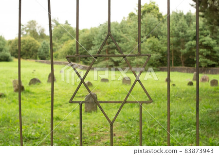 Star of David symbol and sign of the Jews on the iron grate of the old Jewish cemetery. 83873943