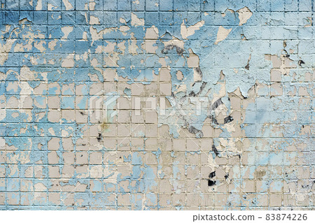 Old street wall with peeling old paint and cracked background texture. Wall with a fluted effect of colored plaster 83874226