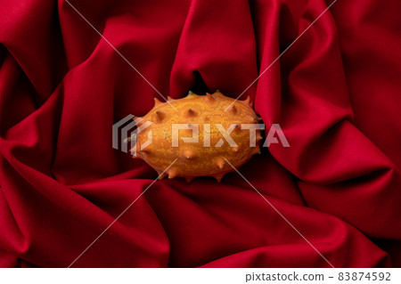 Kiwano image photo of spooky fruit red background Kiwano image photo of spooky fruit red background 83874592