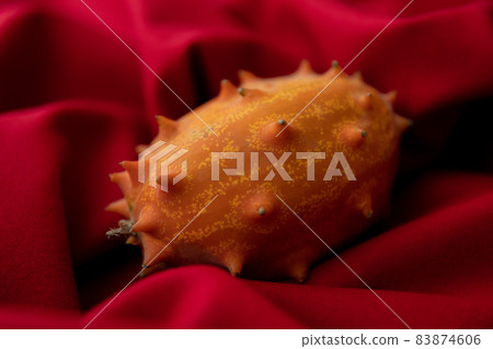 Kiwano 圖像照片的怪異水果紅色背景 83874606