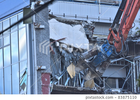 Dismantling site of distribution warehouse Demolition with large heavy machinery 83875110