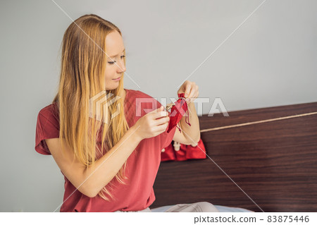 Woman making Christmas advent calendar. Pouches on a rope Woman making Christmas advent calendar. Pouches on a rope 83875446