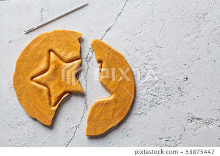 Dalgona Candy - South Korean treat. Round sugar cookie with star inside. Dalgona Candy - South Korean treat. Round sugar cookie with star inside. 83875447