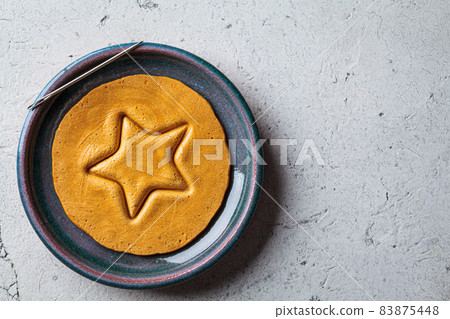 Dalgona Candy - South Korean treat. Round sugar cookie with star inside. Dalgona Candy - South Korean treat. Round sugar cookie with star inside. 83875448