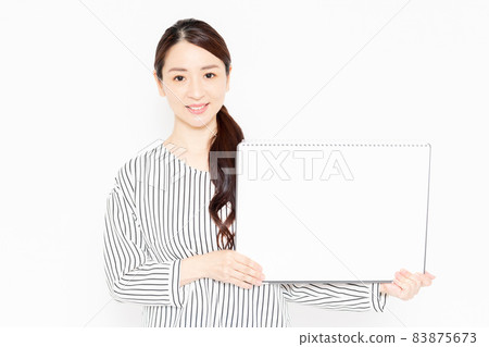 Casually dressed woman with a large sketchbook 83875673