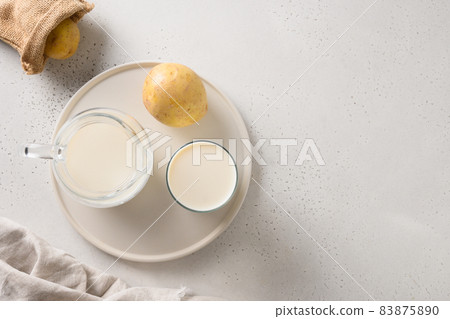Vegan potato milk in glass, plant based milk replacer. 83875890