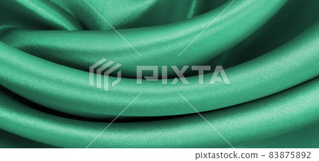 Smooth elegant green silk or satin luxury cloth texture as abstract background. Luxurious background design Smooth elegant green silk or satin luxury cloth texture as abstract background. Luxurious background design 83875892