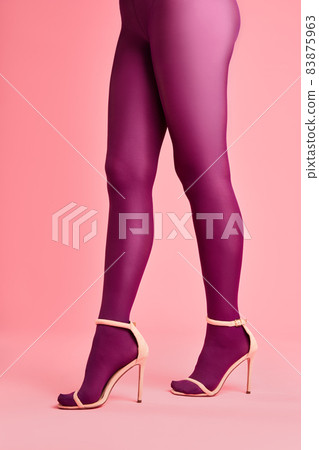 Legs of beautiful young woman in pink tights and stylish high heels shoes on pink background Legs of beautiful young woman in pink tights and stylish high heels shoes on pink background 83875963
