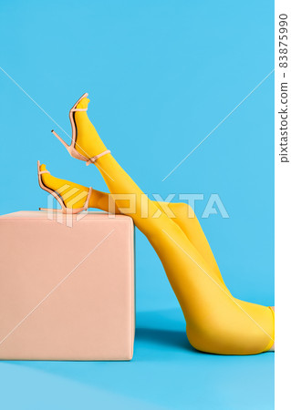 Legs of beautiful young woman raised on modern pouf. 83875990