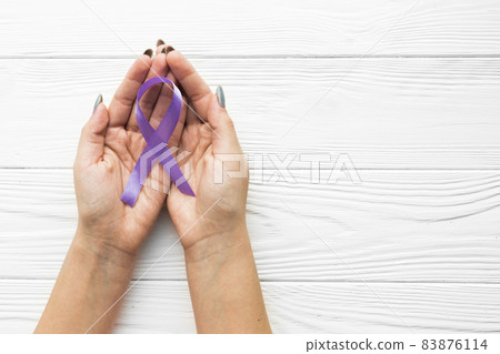 hands with violet ribbon wooden background. High quality beautiful photo concept hands with violet ribbon wooden background. High quality beautiful photo concept 83876114