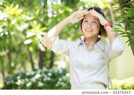 Portrait Asian women teen standing outdoor green with hand sunshade self UV protection happy smile Portrait Asian women teen standing outdoor green with hand sunshade self UV protection happy smile 83876843