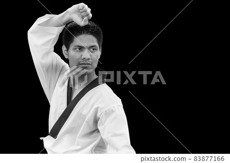 Male in Tiger stand with Taekwondo Asian Martial arts of self defense uniform isolated on black 83877166