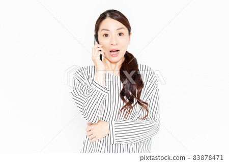 A woman in casual clothes using a smartphone 83878471