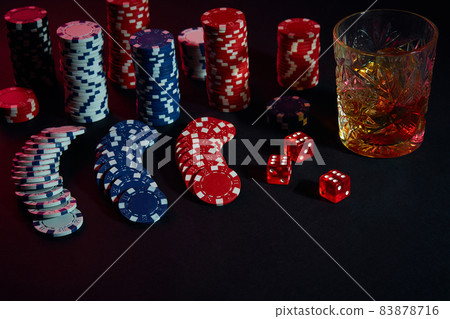 Poker chips and wine glass of cognac on dark table. Gambling Poker chips and wine glass of cognac on dark table. Gambling 83878716