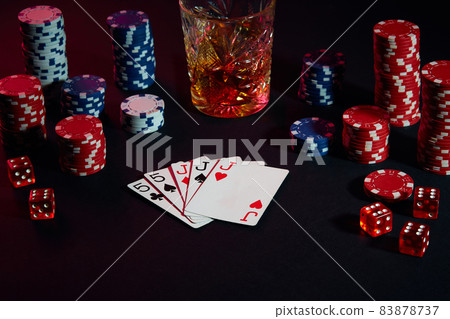 Cards of poker player. On the table are chips and a glass of cocktail with whiskey. Combination of cards Cards of poker player. On the table are chips and a glass of cocktail with whiskey. Combination of cards 83878737