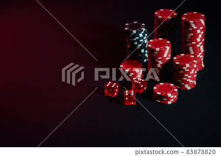 Dice and red and black chips on dark background Dice and red and black chips on dark background 83878820