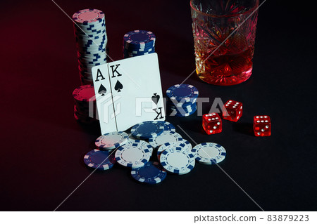 Cards of poker player. On the table are chips and a glass of cocktail with whiskey. Cards - Ace and King 83879223