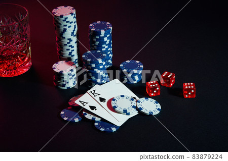 Cards of poker player. On the table are chips and a glass of cocktail with whiskey. Cards - Ace and King 83879224