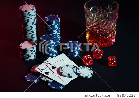 Cards of poker player. On the table are chips and a glass of cocktail with whiskey. Cards - Ace and King 83879225