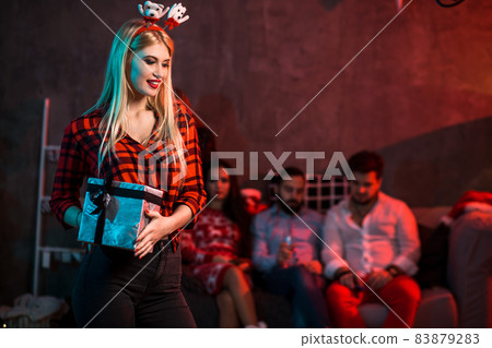 Christmas, x-mas, New year, winter, happiness concept - smiling woman in santa helper hat with gift box 83879283