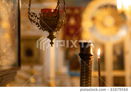 Orthodox Church. Christianity. Festive interior decoration with burning candles and icon in traditional Orthodox Church on Easter Eve or Christmas. Religion faith pray symbol. Orthodox Church. Christianity. Festive interior decoration with burning candles and icon in traditional Orthodox Church on Easter Eve or Christmas. Religion faith pray symbol. 83879568