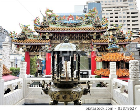 異國情調橫濱唐人街關天皇陵門和屋頂、柱子、金屬香爐和長香棒 異國情調橫濱唐人街關天皇陵門和屋頂、柱子、金屬香爐和長香棒 83879627