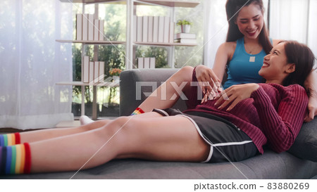 Happy pregnant lesbian couple spending time together at home. Happy pregnant lesbian couple spending time together at home. 83880269