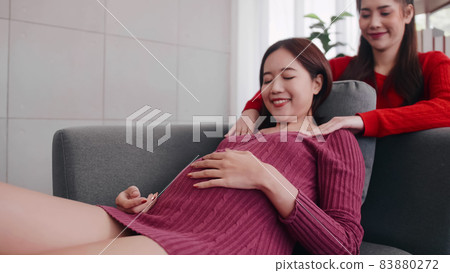Happy pregnant lesbian couple spending time together at home. 83880272