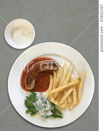 top view Sausage and boiled Vegetable with Cream Sauce and French fries on a white ceramic plate,grey floor 83882267