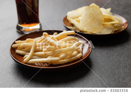 French fries snack, Potato chips and a glass of cola. Food and drink concept. French fries snack, Potato chips and a glass of cola. Food and drink concept. 83883358