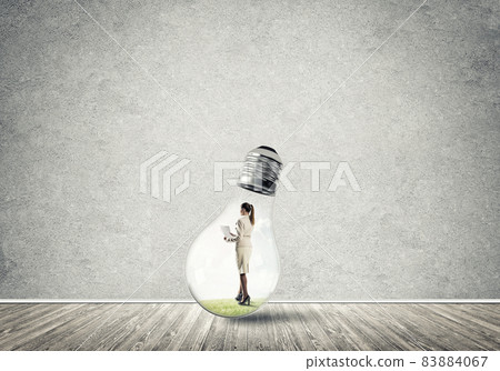 Businesswoman trapped in bulb Businesswoman trapped in bulb 83884067