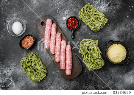 Raw Tagliatelle sausages ingredients, on black dark stone table background, top view flat lay 83884699